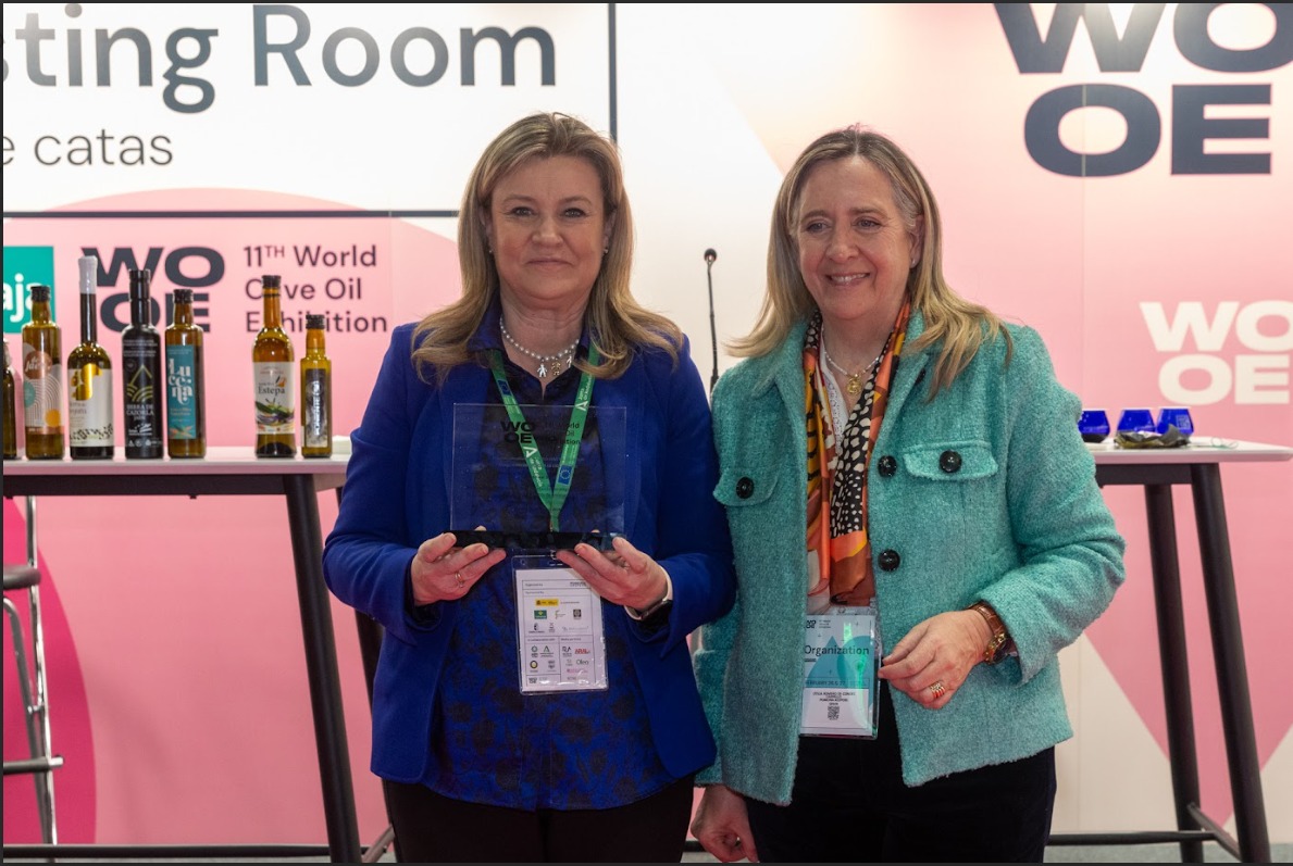 Cristina del Toro, directora general de Industrias, Innovación y Cadena Agroalimentaria, y la responsable de organización de la World Olive Oil Exhibition.