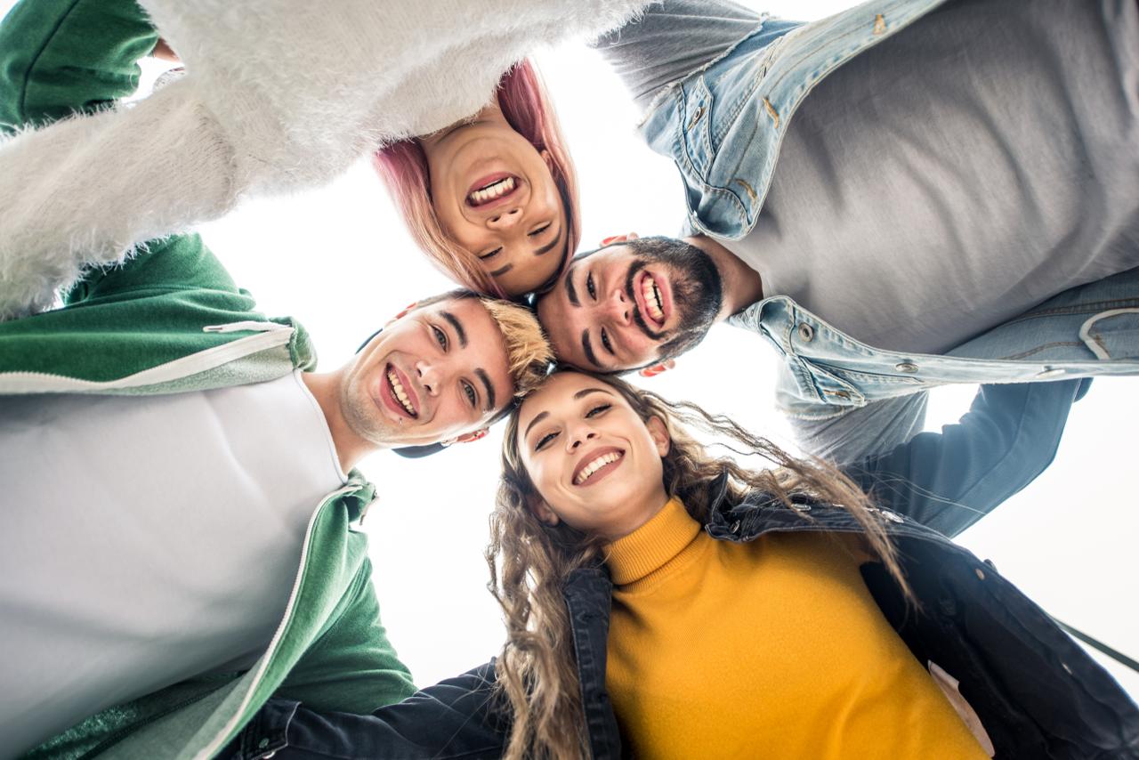 Grupo de jóvenes posando en círculo.