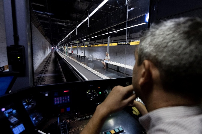 Un maquinista de Metro de Madrid conduce un convoy qye está entrando en una estación